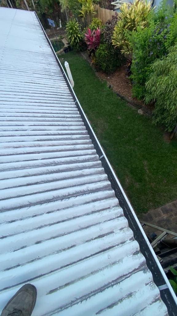 Long run of roof gutter cleared of debris along a house roofline